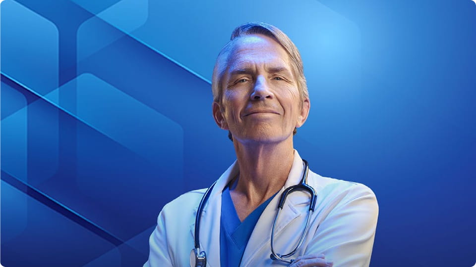 Dr James Schultz, MD, in a white coat and stethoscope, smiling with arms crossed.