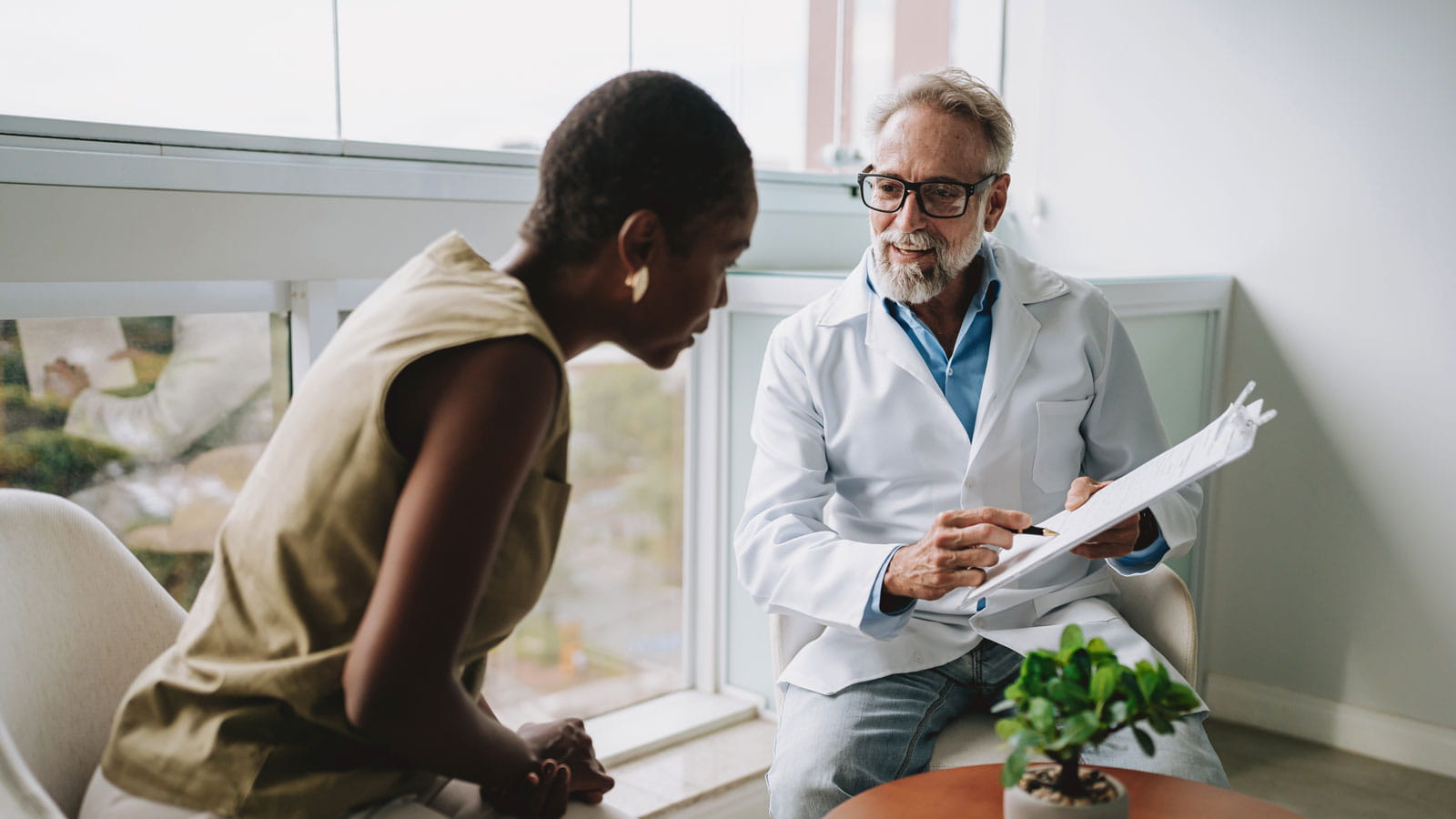 A woman is being shown her medical chart as she consults with her doctor.