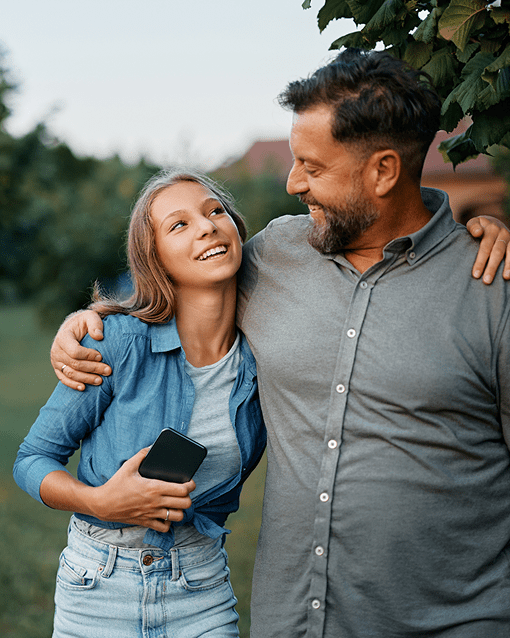 Father holding young daughter outdoors — symbolizing family and prevention.