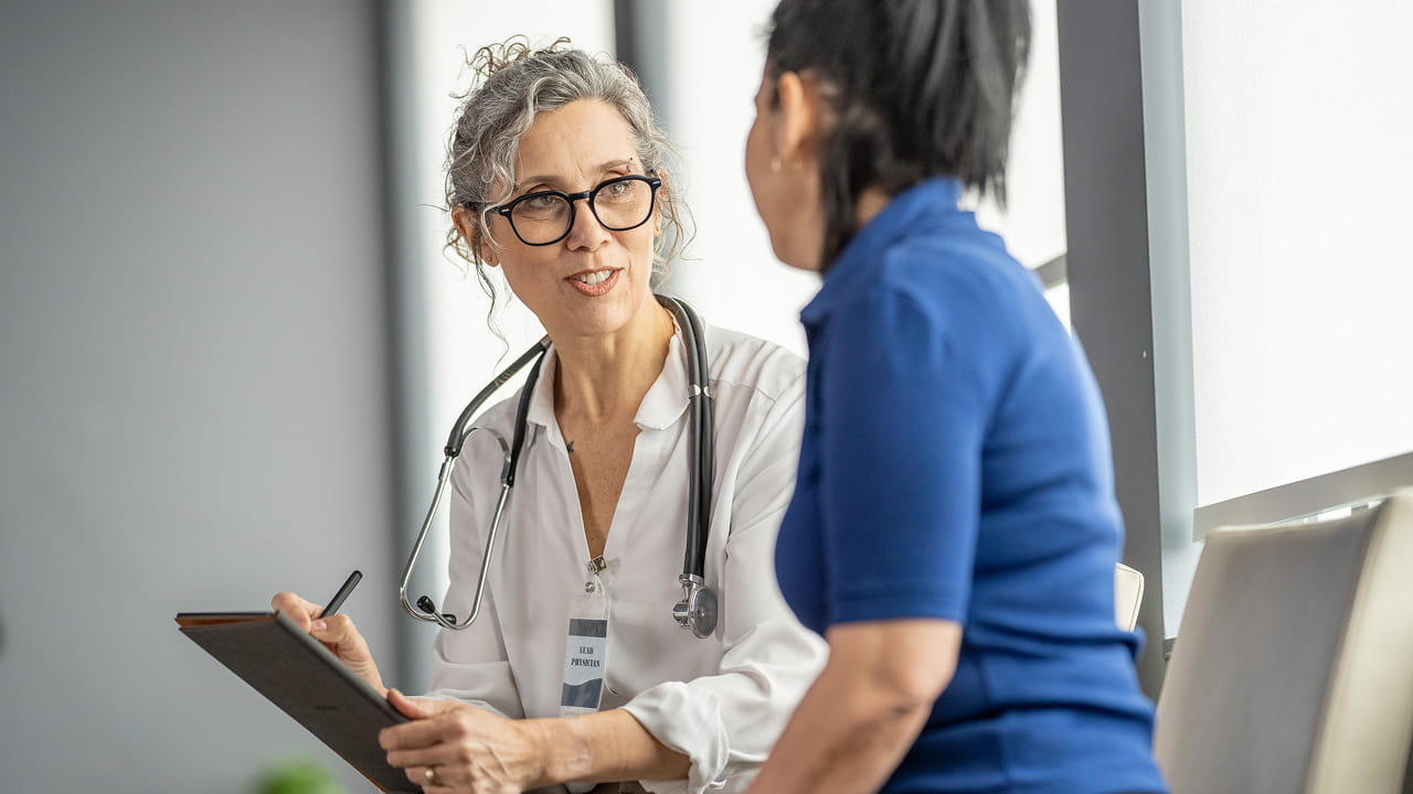 A doctor in consultation with a patient in a hospital setting.