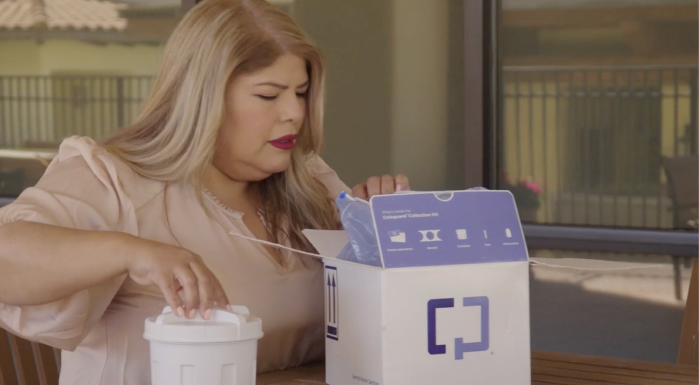 Yla, a patient who screened with Cologuard, opening the collection kit box and removing the sample container from inside