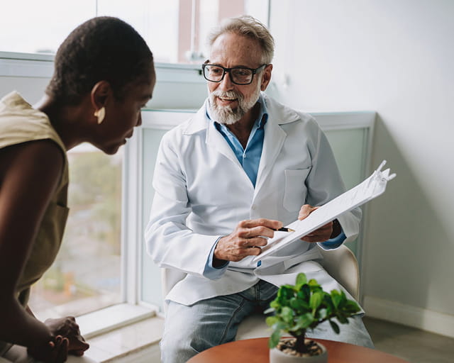 A patient consults with her doctor in his clinic.
