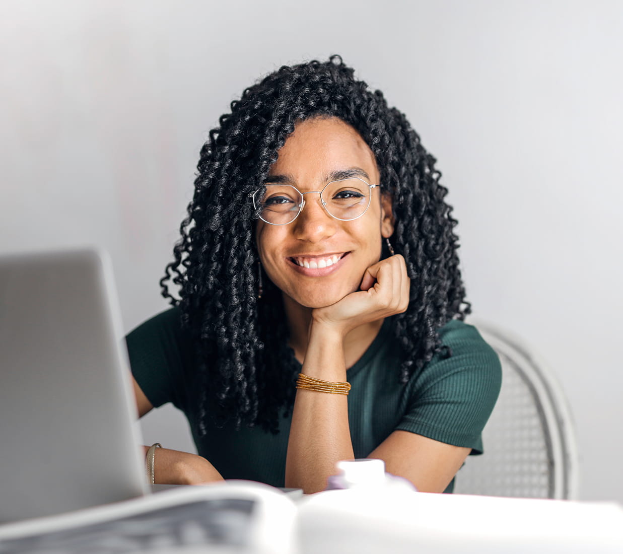 A smiling woman sitting at a laptop.