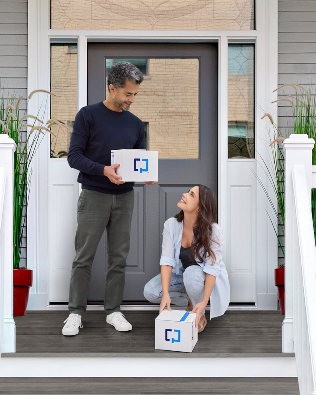Couple on porch picking up delivered Cologuard test kits.